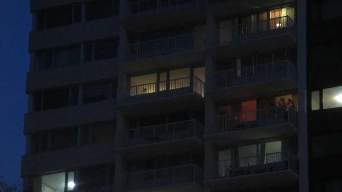 Apartment patios in the night with a few lights on
