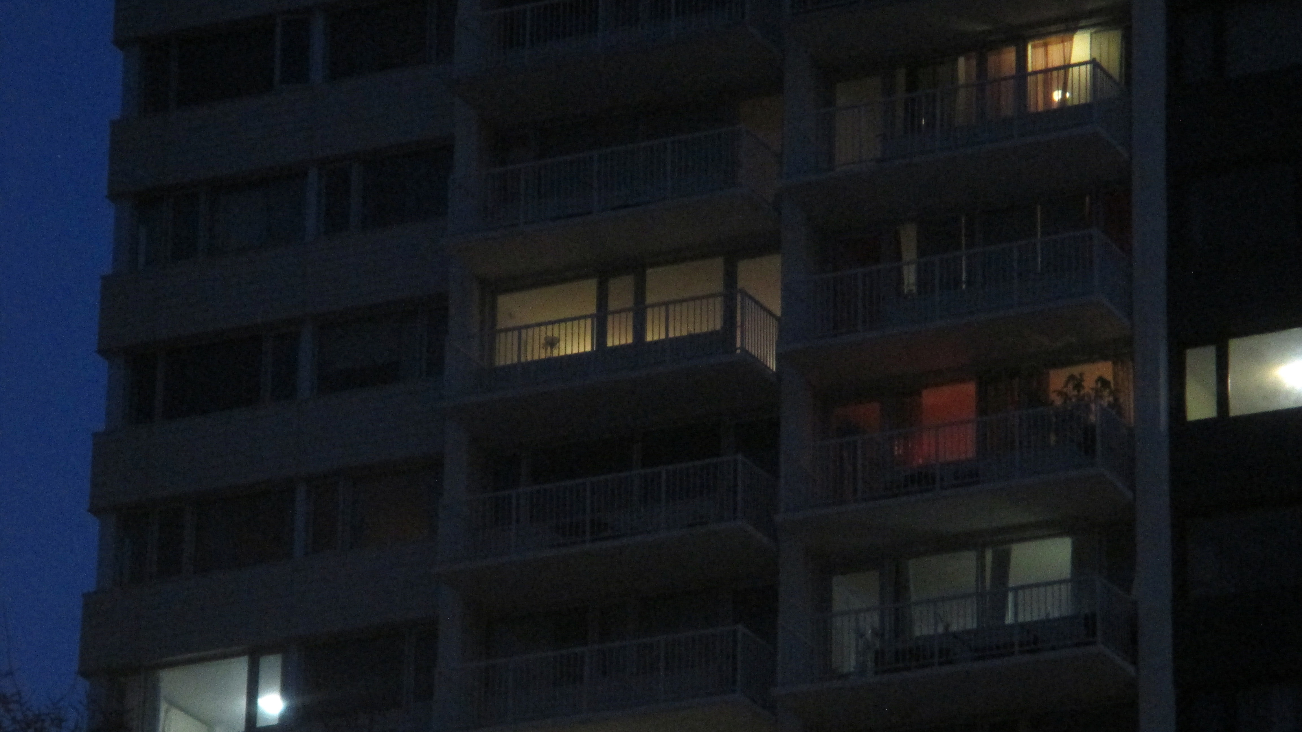 Apartment patios in the night with a few lights on