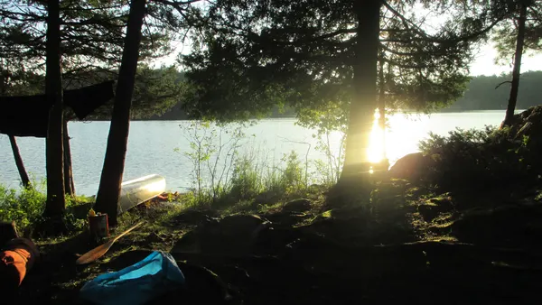 Old camera image of sunset reflecting off canoe