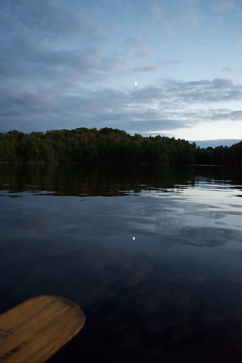 Imag of a dark lake taken from a canoe