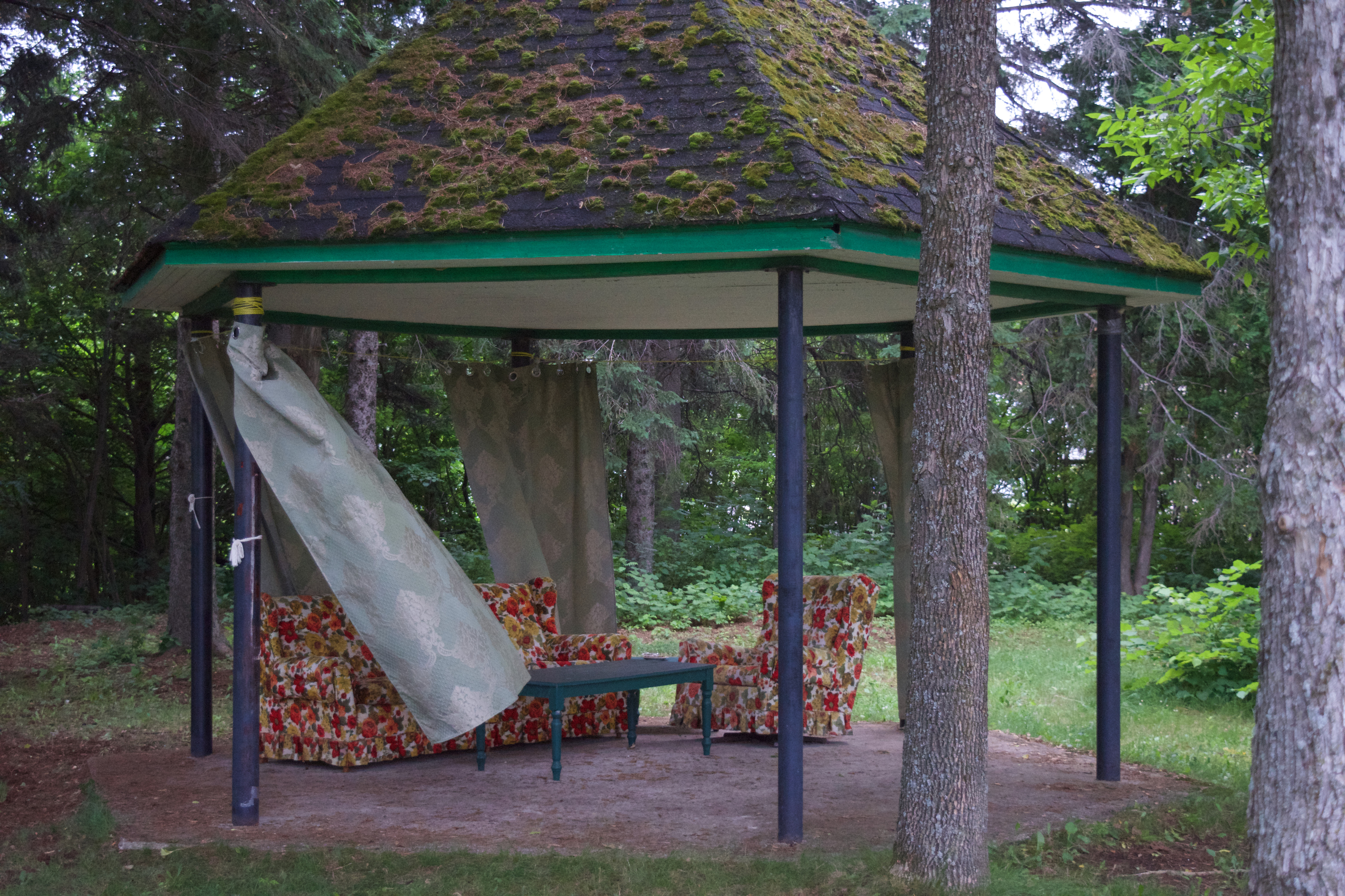 A gazebo with curtains flowing in the wind