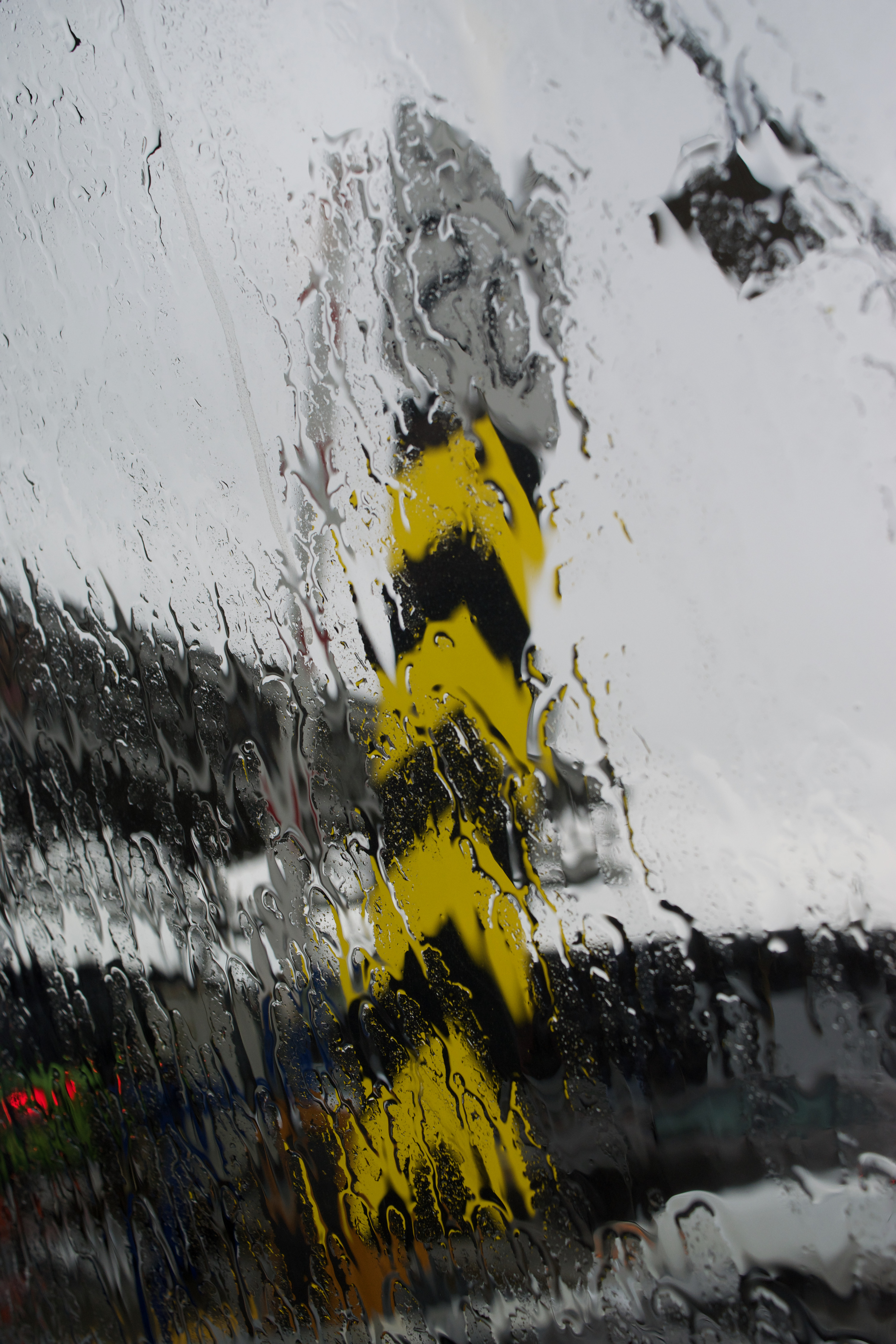 A road sign behind water on a window