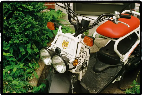 A brightly coloured scooter covered in stickers